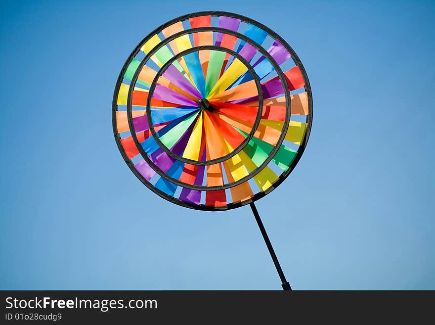 Plastic colourful pinwheel on the blue background