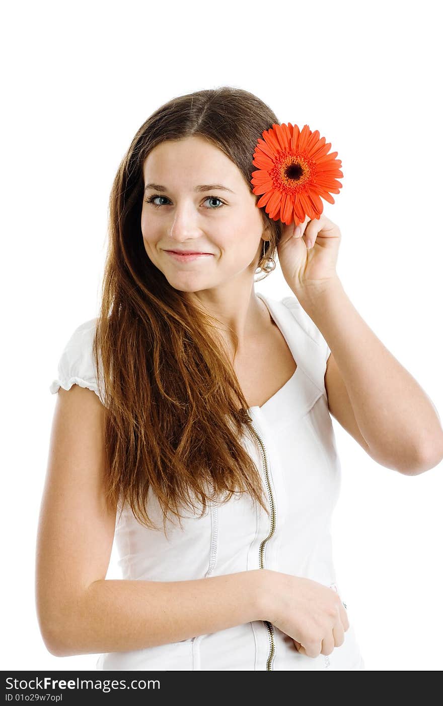 A smiling beautiful young woman in a white dress with a bright red flower near her face. A smiling beautiful young woman in a white dress with a bright red flower near her face