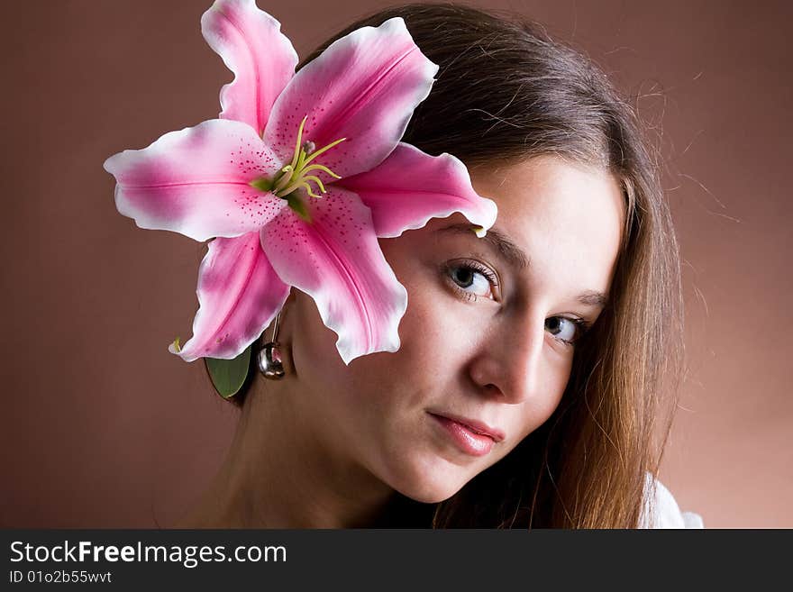 Young woman posing with a pink lily