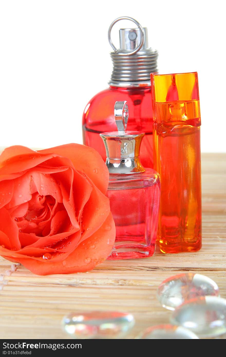 Perfume bottles with flower rose and glass pebbles