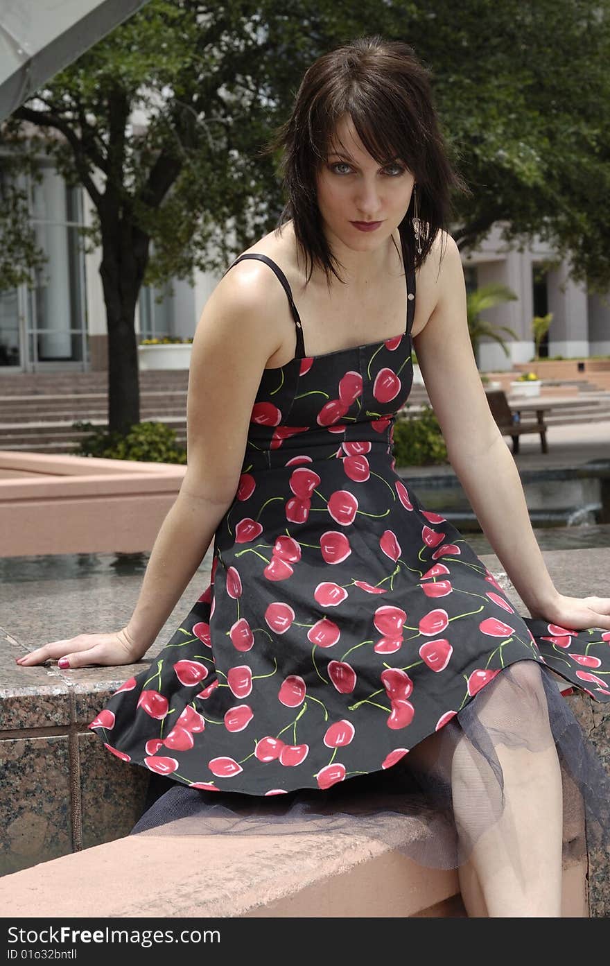 An attractive young girl in a cherry print dress looking at the camera. An attractive young girl in a cherry print dress looking at the camera