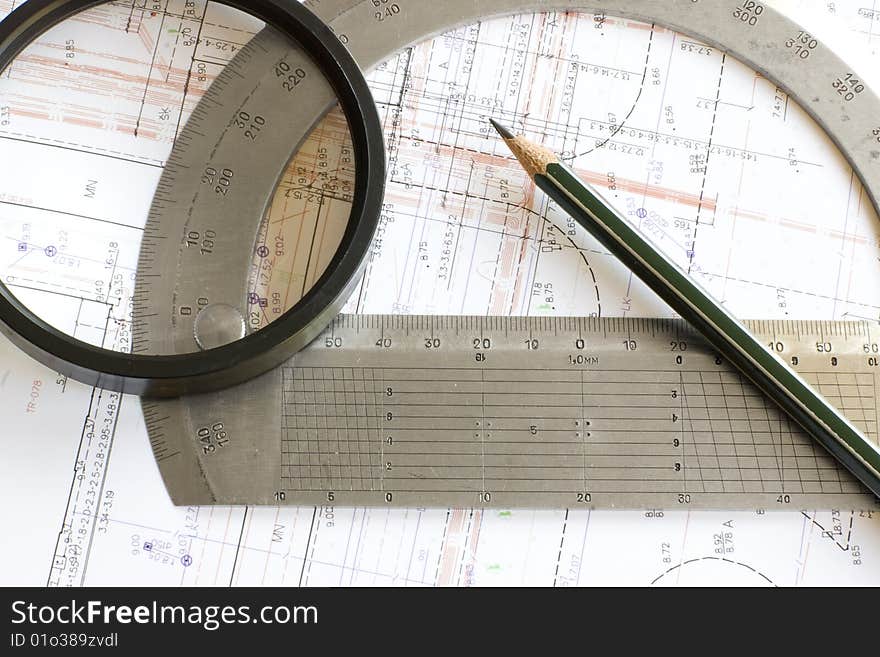 Blueprint with pencil, loupe and steel protractor