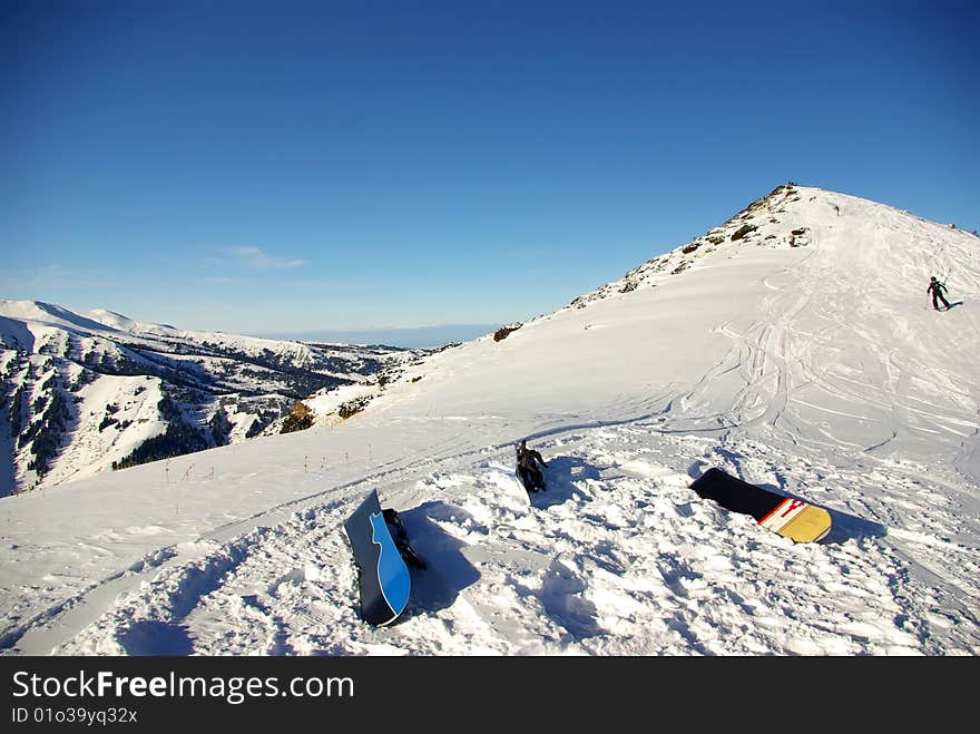 Three snowboards on the snow, ready to ride