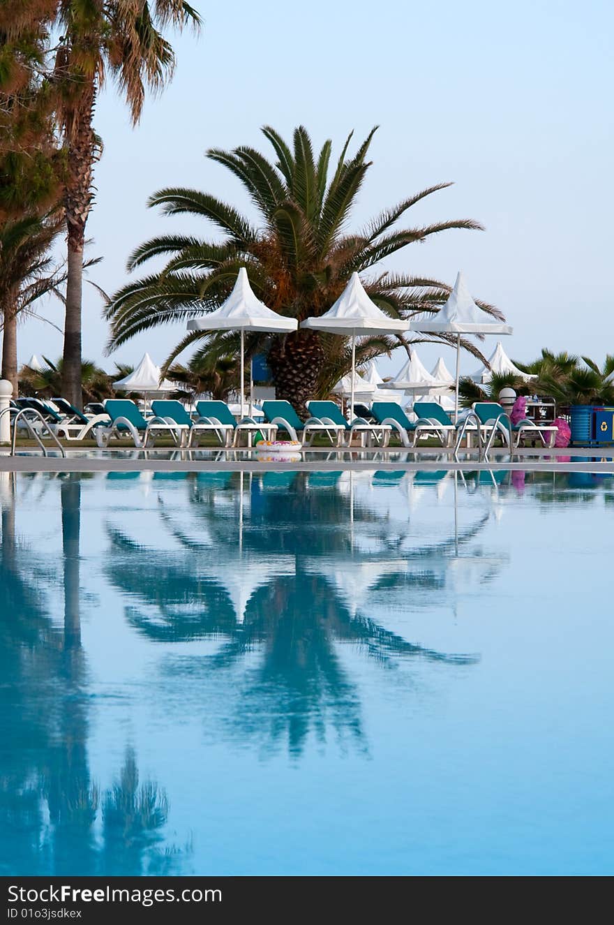 Pool with palms reflecting in the water on a seaside resort