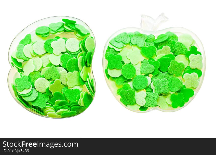 Geometrical figures of different shades of green poured into transparent containers in the form of apple