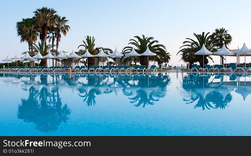 Pool with palms reflecting in the water on a seaside resort