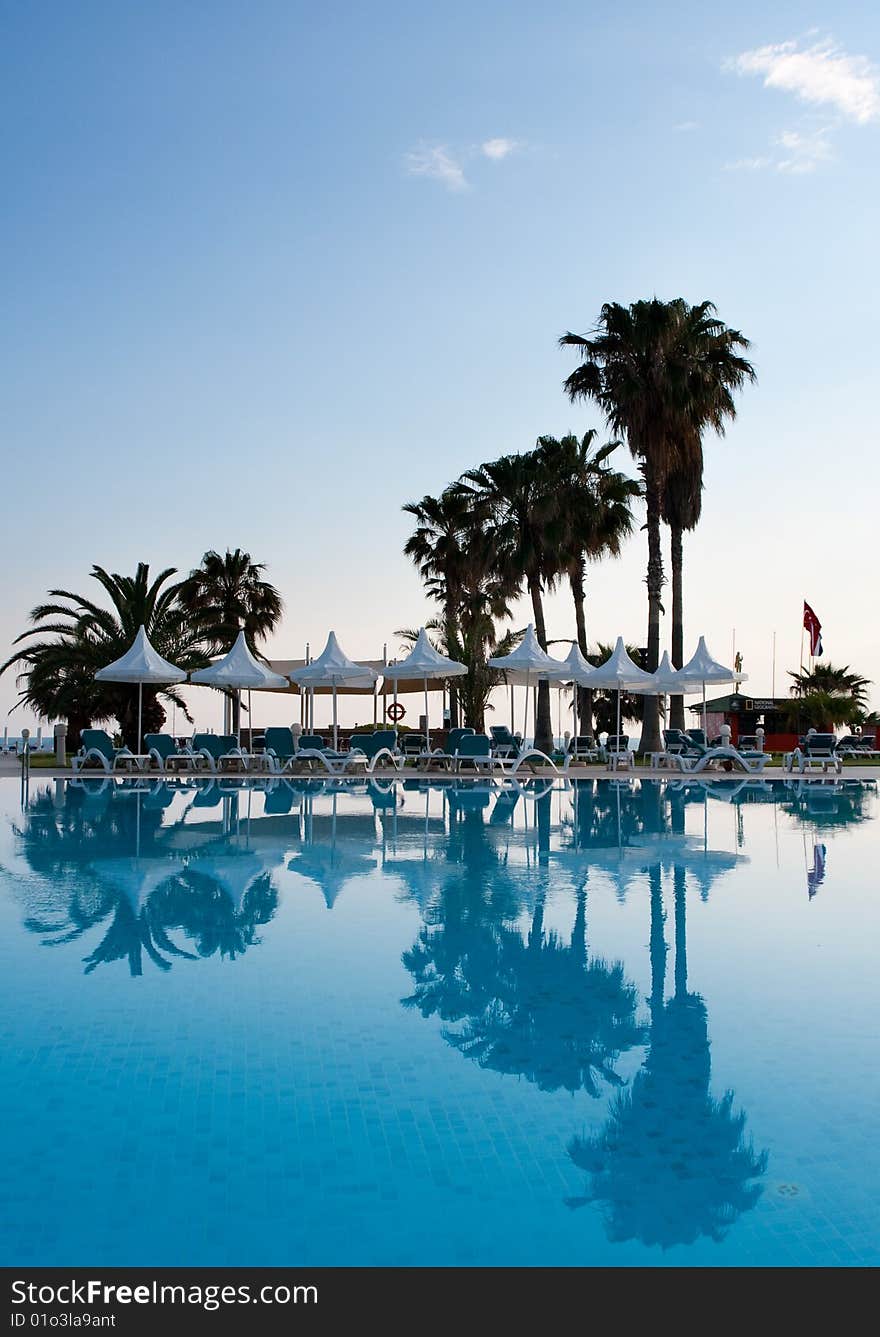 Pool with palms reflecting in the water on a seaside resort