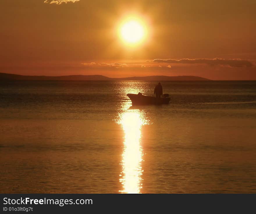 Fisherman on sea in red sunset. Fisherman on sea in red sunset