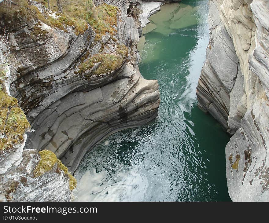 Looking down at the pathway the cold river water takes in a canyon in the Canadian Rockies. Looking down at the pathway the cold river water takes in a canyon in the Canadian Rockies.