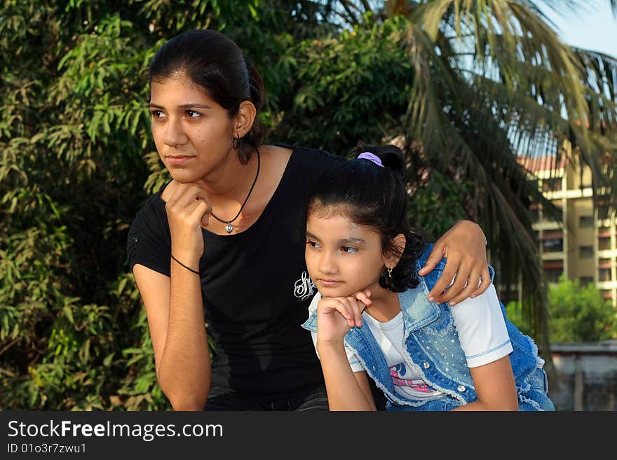 A small girl and her young sister engrossed in deep thoughts. A small girl and her young sister engrossed in deep thoughts.