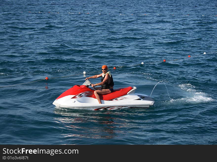 An adult man on a wave runner at sea