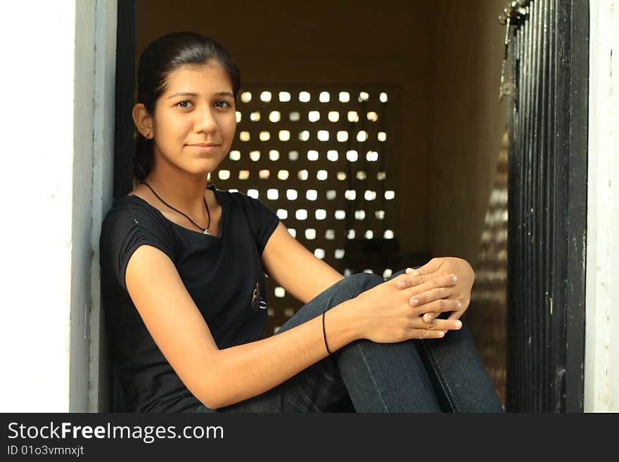 A nice Indian girl sitting relaxed in front of her house. A nice Indian girl sitting relaxed in front of her house.