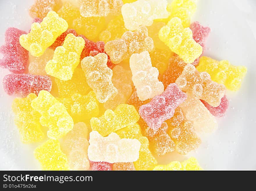 Multicolored jelly sweets covered by sugar in the shape of bear cubs. Multicolored jelly sweets covered by sugar in the shape of bear cubs.