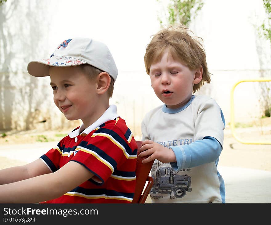 Boys play on a children's playground in the spring. Boys play on a children's playground in the spring