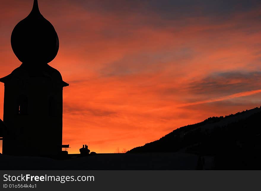 A beautiful sunset behind a church in the Alps. A beautiful sunset behind a church in the Alps.