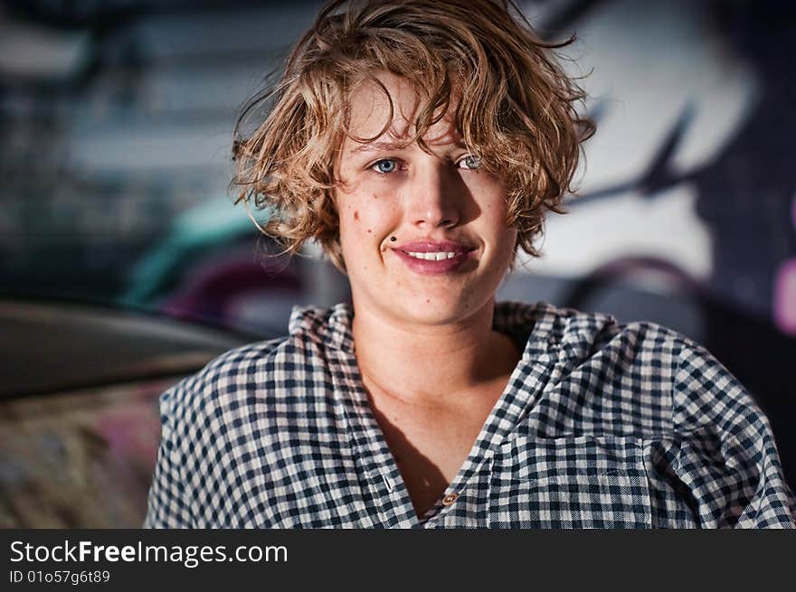 Young girl sitting on old car in grungy alley. Young girl sitting on old car in grungy alley