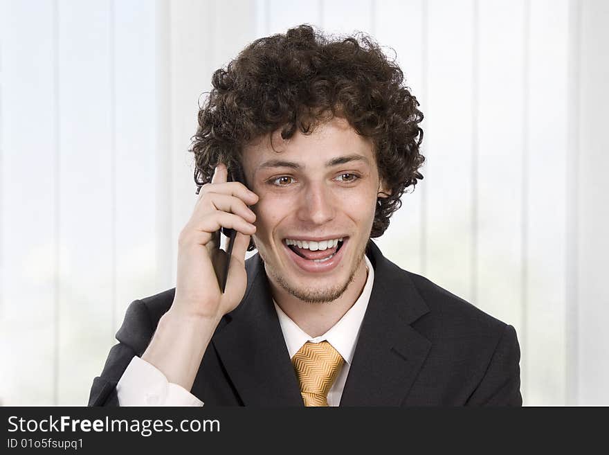 Happy gesturing business man with mobile phone