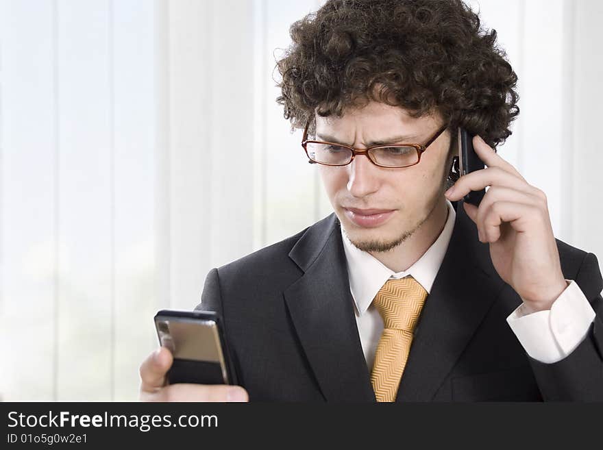 Troubled business man with two mobile phone