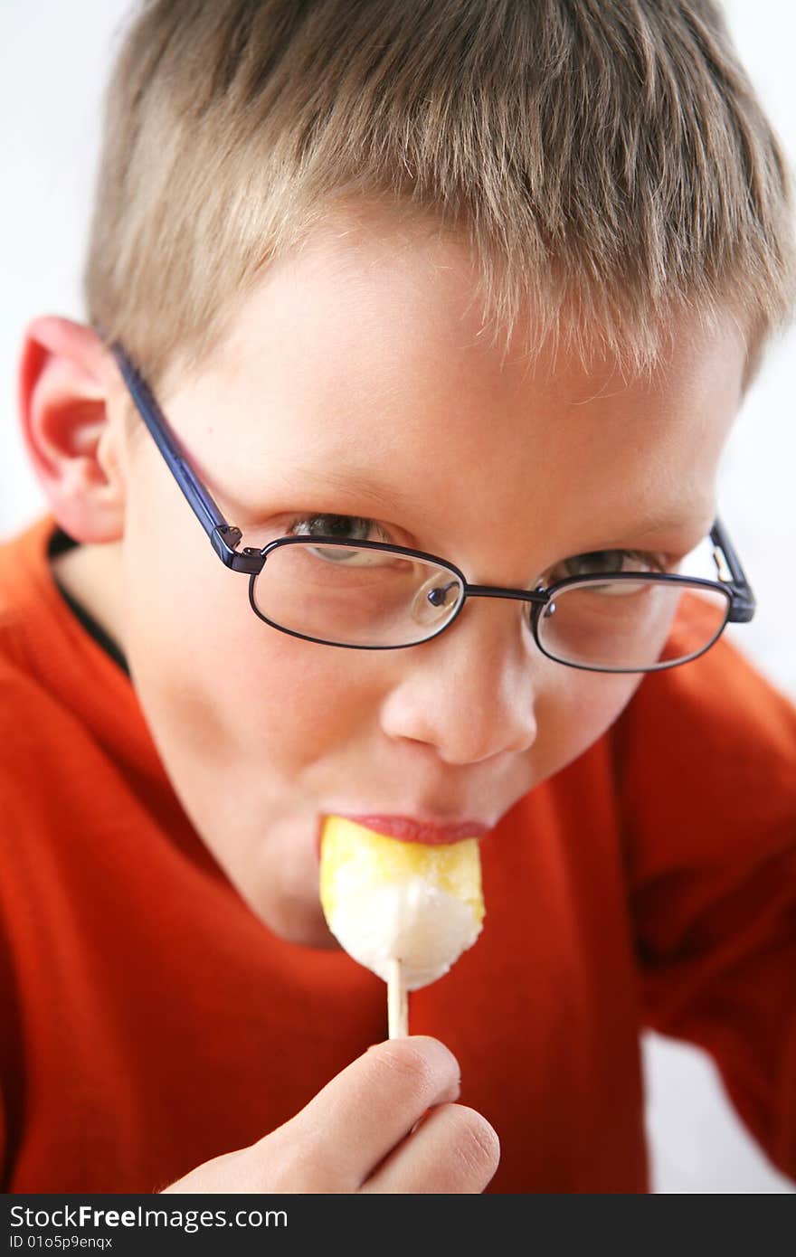 Boy eating yellow ice cream. Boy eating yellow ice cream.