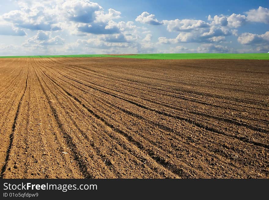 Beautiful landscape image of ploughland and dramatic cloudy sky.