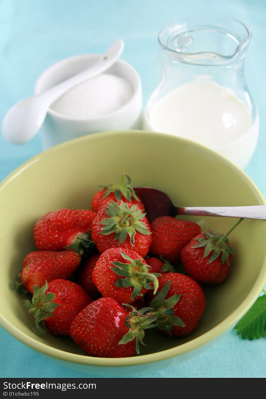 Strawberries in bowl, jug of milk or yoghurt and sugar. Strawberries in bowl, jug of milk or yoghurt and sugar.