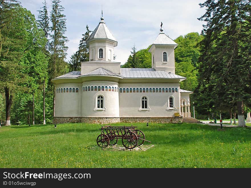 Romanian  orthodox church and an old waggon