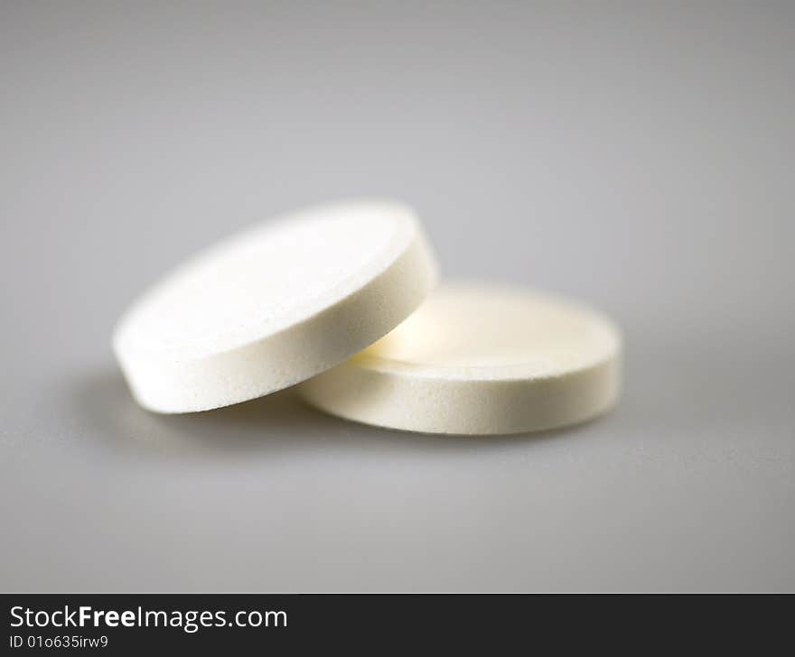 Two white pills in focus