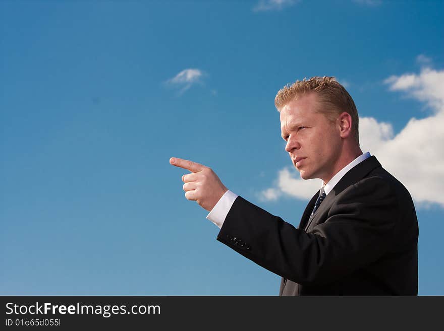 A businessman points off camera. A businessman points off camera