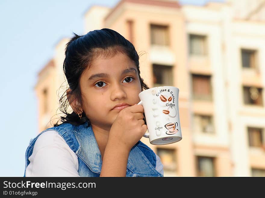 A girl in deep thinking over her problem over a cup of coffee. A girl in deep thinking over her problem over a cup of coffee.