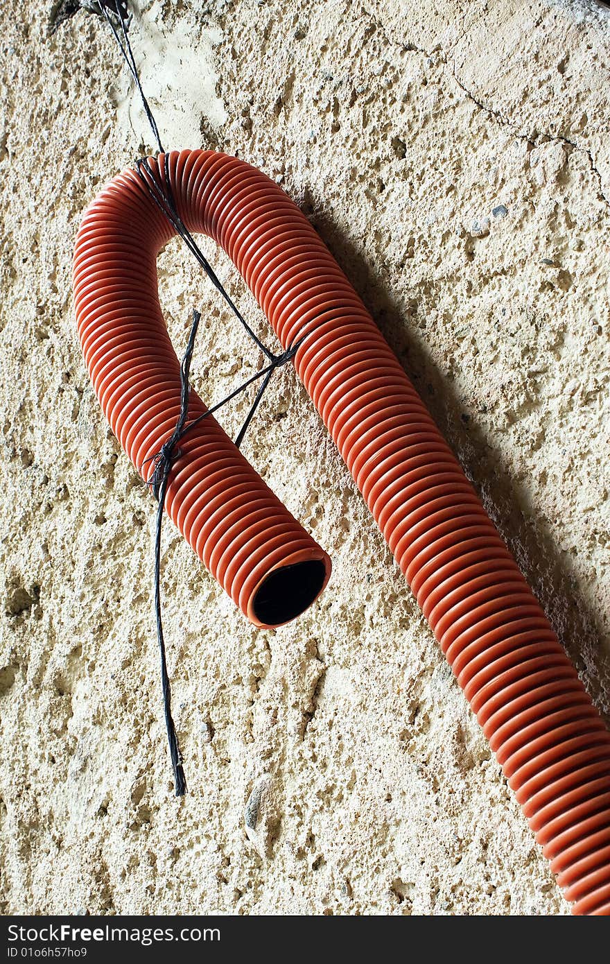 Red plastic tube attached to the wall. Red plastic tube attached to the wall