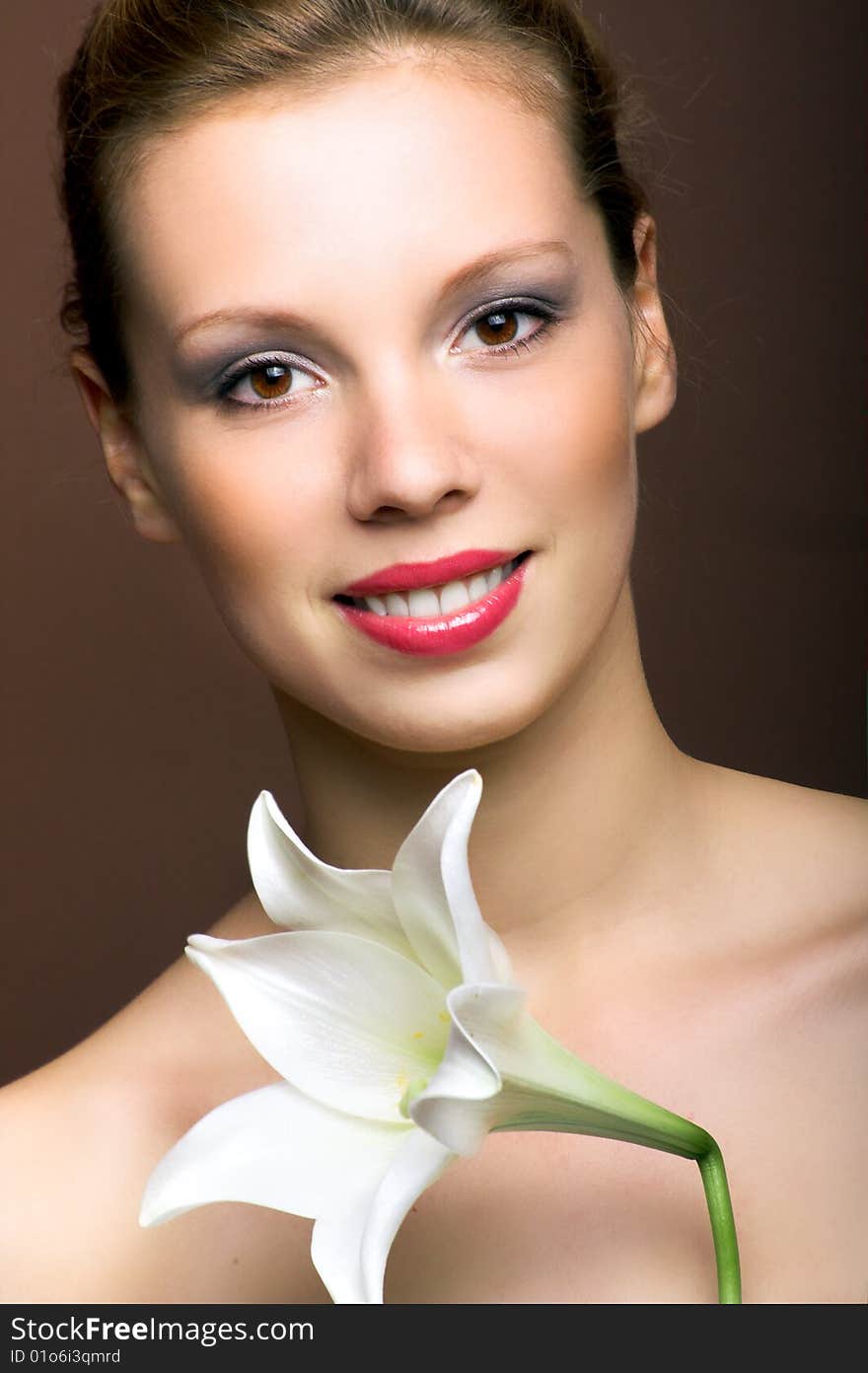 Beauty portrait of a young woman with a lily flower. Beauty portrait of a young woman with a lily flower