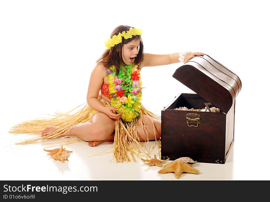 A preteen hula girl delighted with the treasures found an old pirate trunk. Isolated on white. A preteen hula girl delighted with the treasures found an old pirate trunk. Isolated on white.