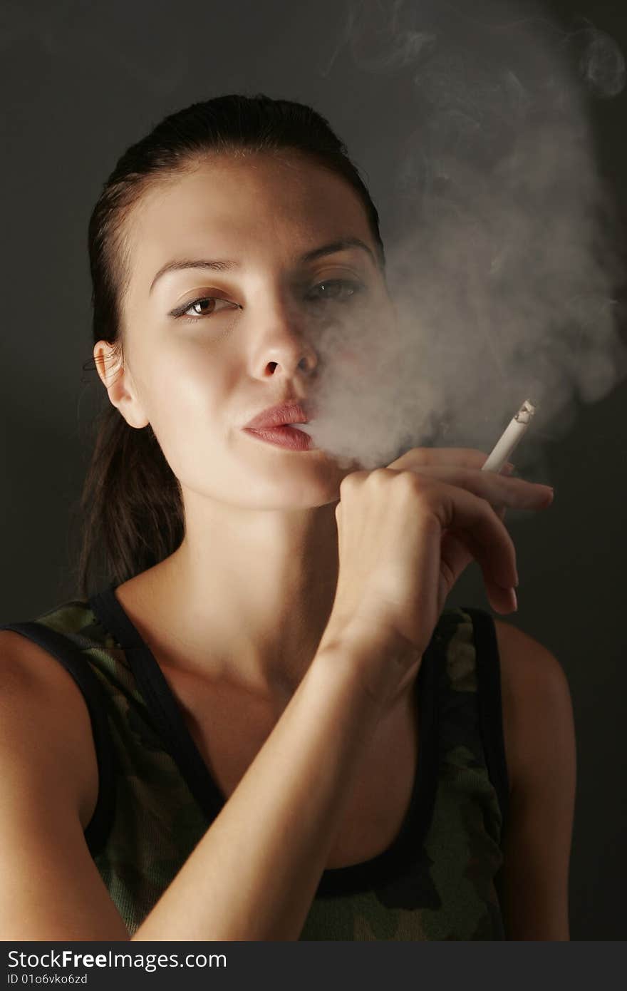 girl in camouflage with cigarette, studio shot. girl in camouflage with cigarette, studio shot