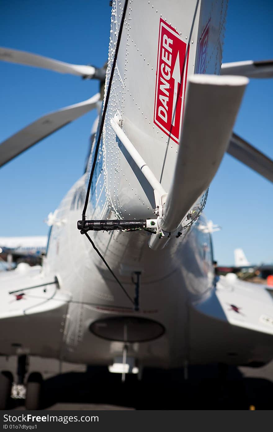 White helicopter tail with red danger sign against blue sky