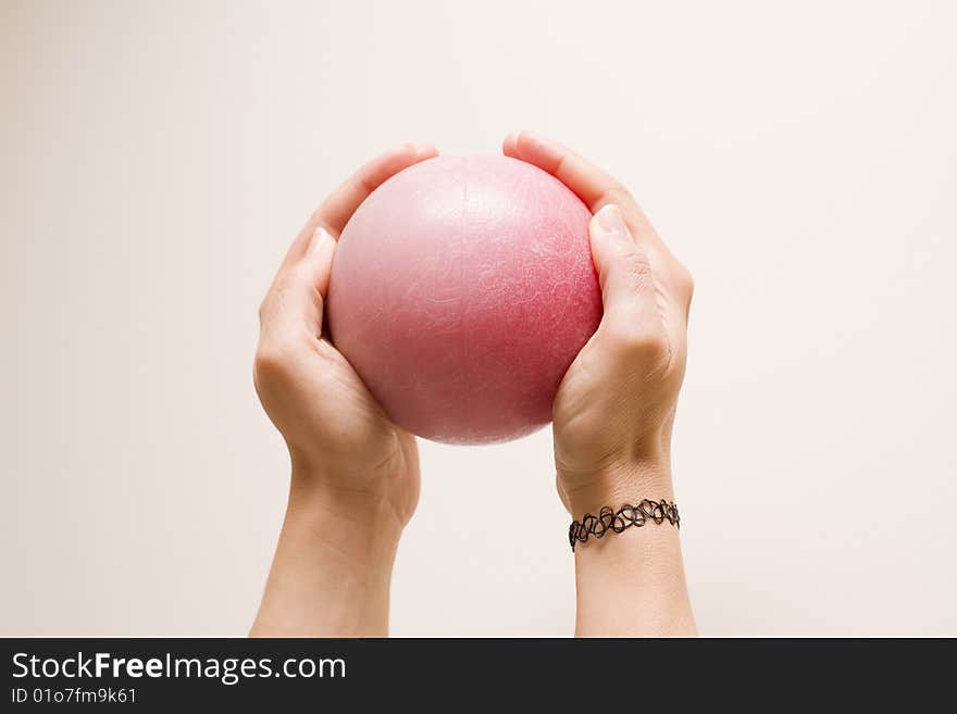 Two female hands holding a red ball. Two female hands holding a red ball