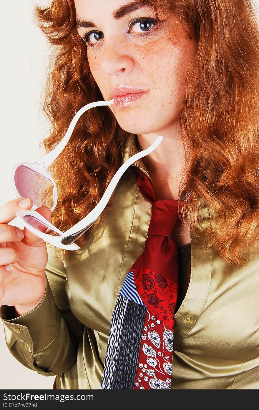 Pretty bright red haired woman in a gold blouse and necktie with an 
white sunglasses in close-up. Pretty bright red haired woman in a gold blouse and necktie with an 
white sunglasses in close-up.