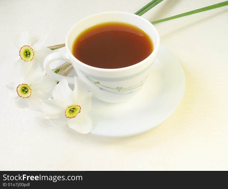 Cup of tea and narcissus flowers