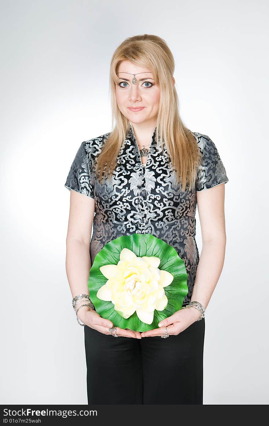 Attractive woman with lotus flower, studio shot