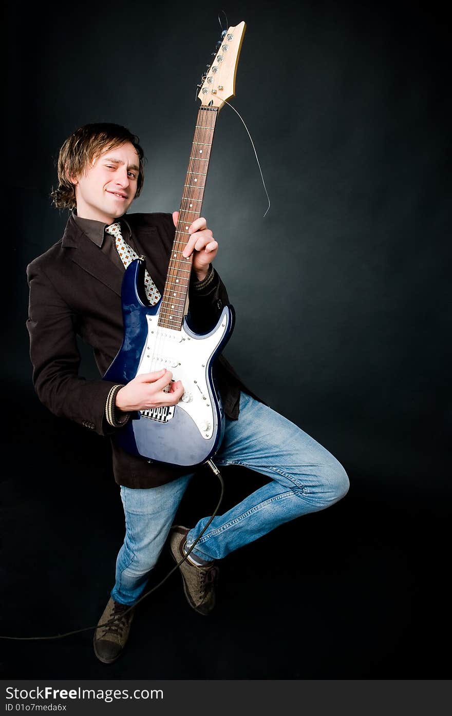 Man playing electro guitar over black background