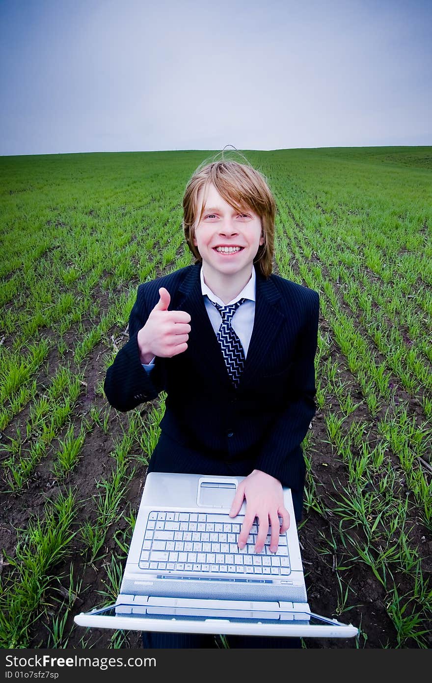 Smiling businessman with laptop outdoors