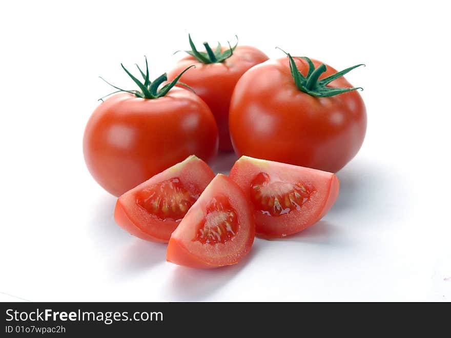 Red tomatoes and slices on a white background