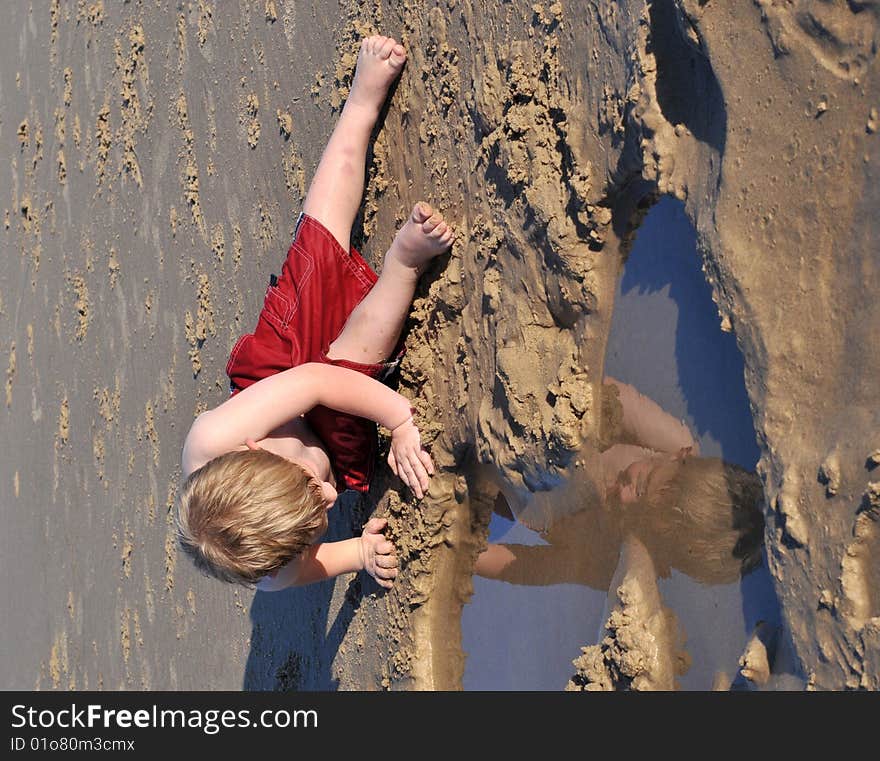 Boy looking at his reflection at the beach. Boy looking at his reflection at the beach