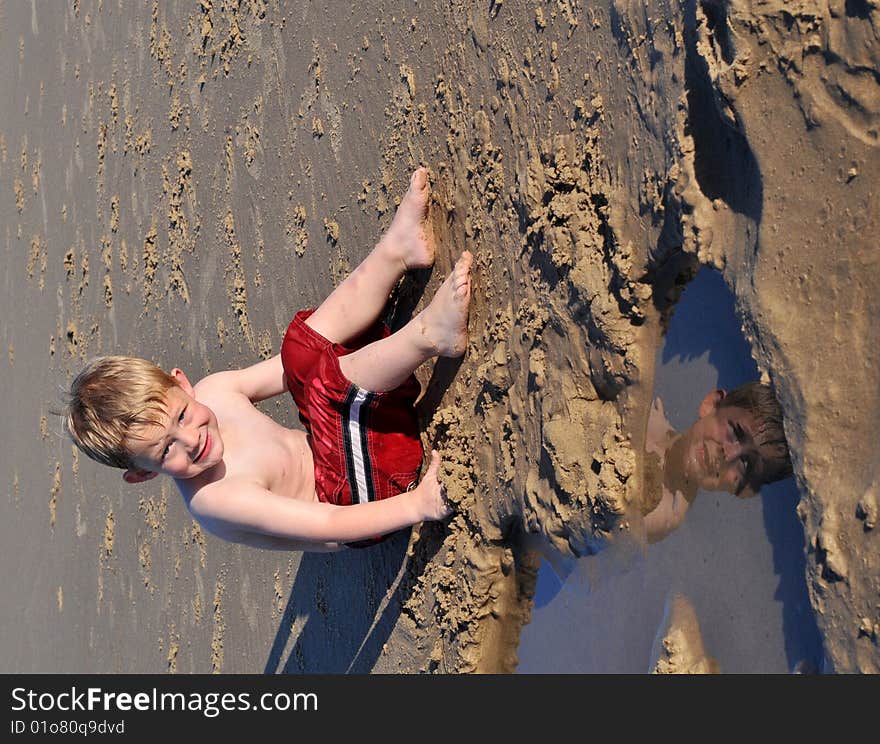 Boy reflected in puddle at the beach. Boy reflected in puddle at the beach