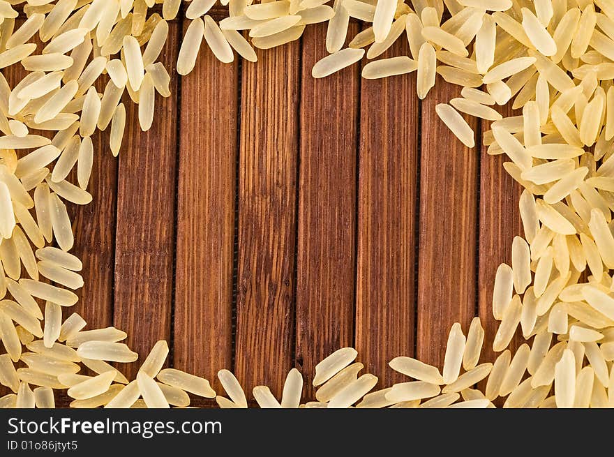 Frame of uncooked rice on bamboo mat with copy space.