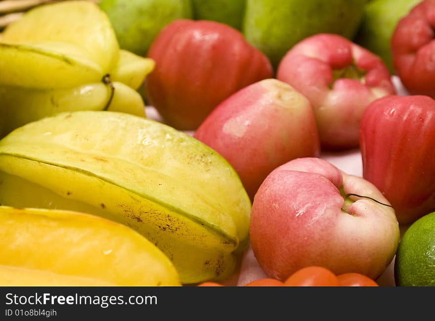 Tropical fruits in a basket, including starfruit; mango, lime and pink guava. Tropical fruits in a basket, including starfruit; mango, lime and pink guava.