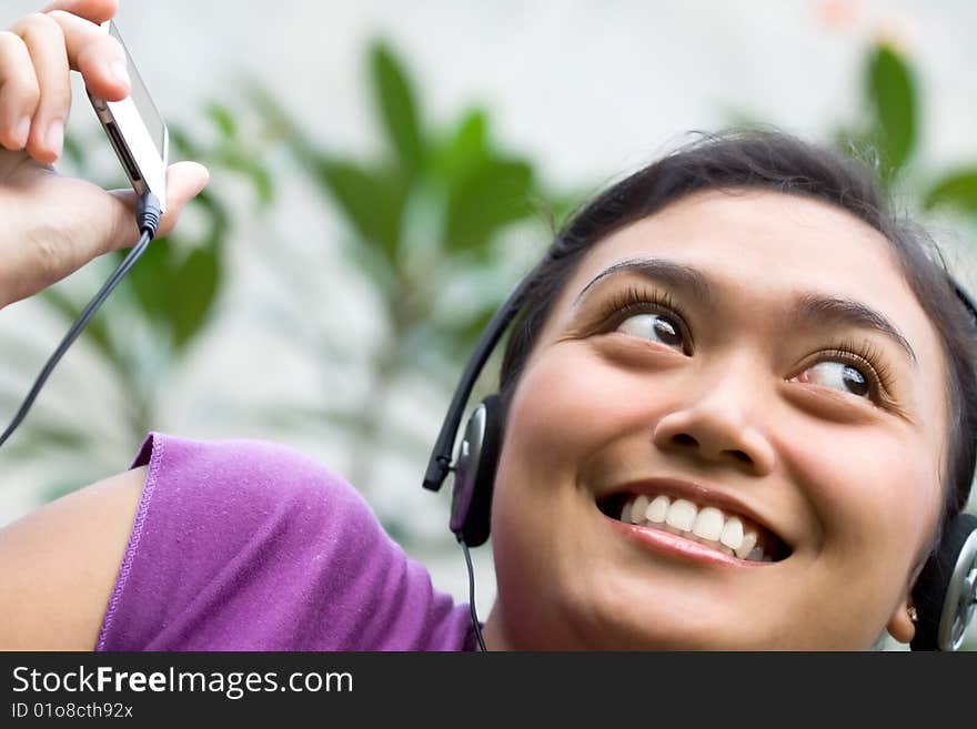 Beautiful asian young woman with headphone listening music from mp3 player. Beautiful asian young woman with headphone listening music from mp3 player