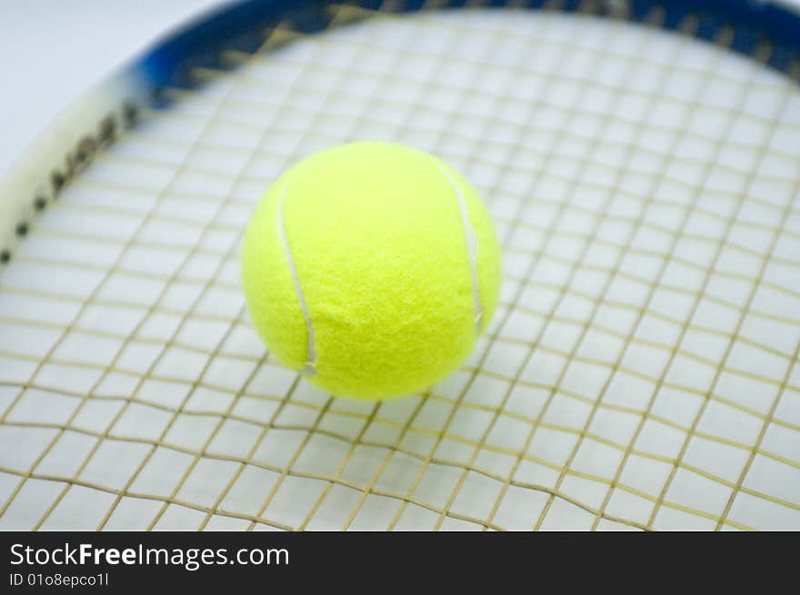 A tennis ball nestled on a raquet.