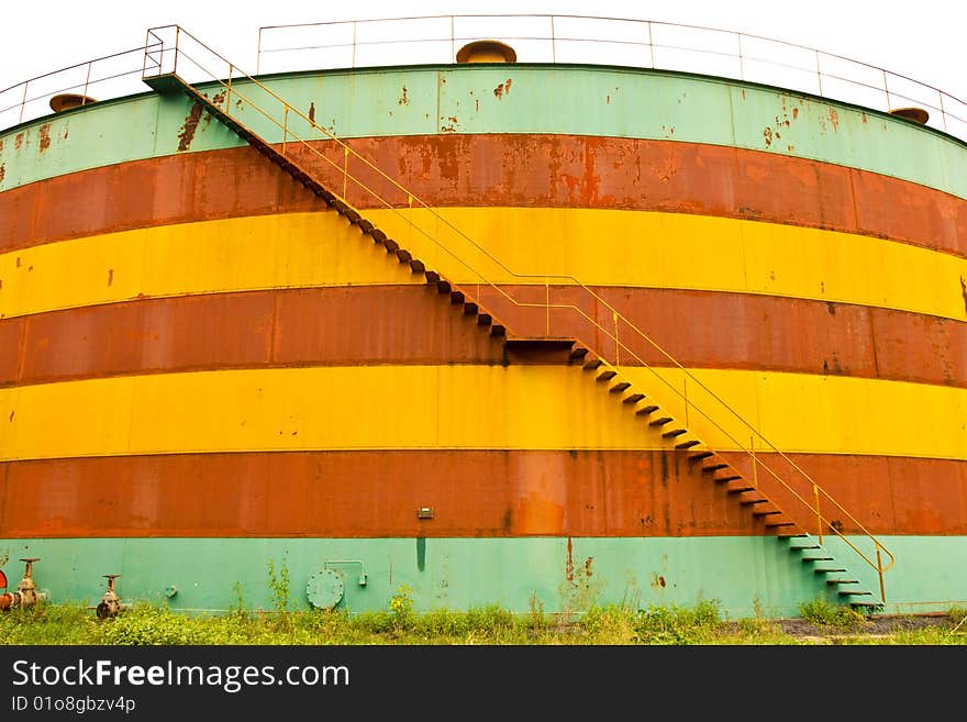 Deserted colorful oil tank with stair. Deserted colorful oil tank with stair