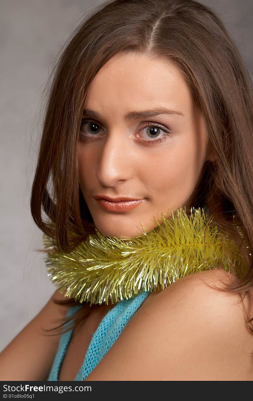 Young model in a blue dress on a grey background