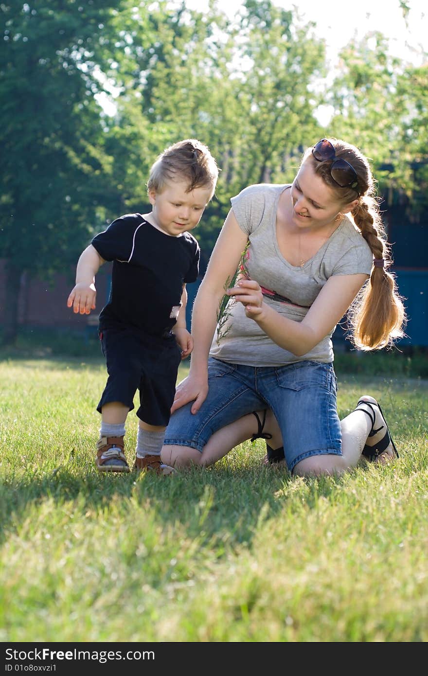 Mother and son playing on the grass in the yard of the house. Mother and son playing on the grass in the yard of the house.